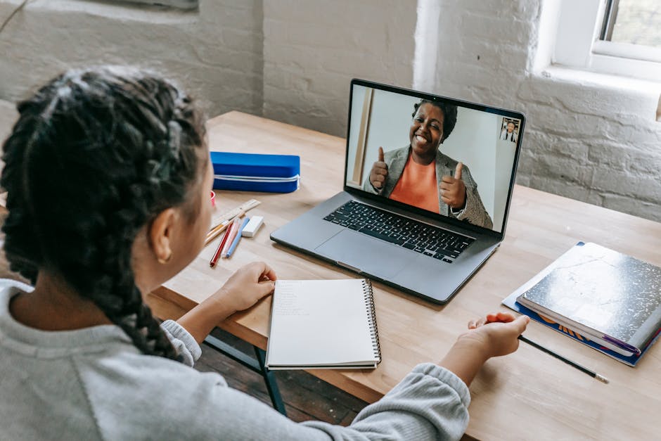 Ethnic girl having video chat with teacher online on laptop